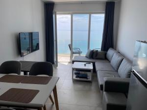 a living room with a couch and a view of the ocean at Ocean View Beach Apartment in Shëngjin