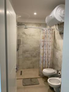 a bathroom with a shower with a toilet and a sink at Ocean View Beach Apartment in Shëngjin
