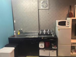 a small kitchen with a sink and a microwave at 民泊寿屋Kotobukiya Guesthouse in Muroran