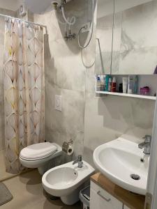 a bathroom with a toilet and a sink and a shower at Ocean View Beach Apartment in Shëngjin +3 photos