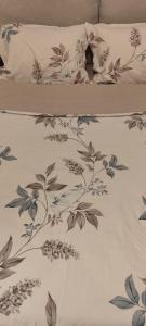 ein Bett mit einer Decke mit Blumenmuster in der Unterkunft Magic in Razvala