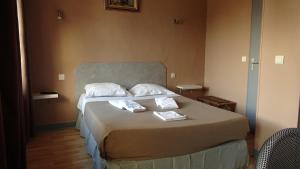 a bedroom with a bed with two towels on it at L'Hôtel de la Taverne in Étretat +8 photos