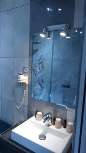 a bathroom with a sink and a mirror at L'Hôtel de la Taverne in Étretat