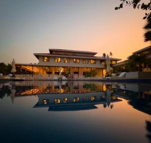 a building with a pool in front of it at sunset at Belizean Bliss in Maya Beach