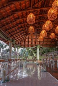 a pavilion with chairs and chandeliers and tables at Finca Campestre Colibrí in Quebradanegra
