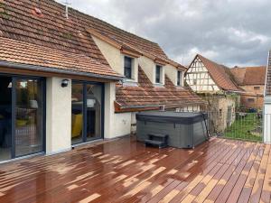 a deck with a television on top of a house at A l'Ancienne Ferme in Steinseltz