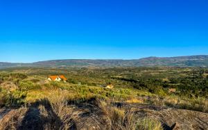 a house on a hill with mountains in the background at Quinta da Estrela in Ponte Nova