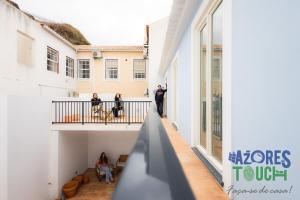 a group of people standing on the balcony of a building at Hostel Casa São Pedro in Angra do Heroísmo +27 photos