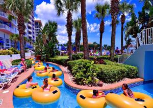 a group of people in tubes in a pool at a resort at Wyndham Ocean Walk 2 BR Resort Condo Direct Oceanfront - Daytona Funland 22260 in Daytona Beach