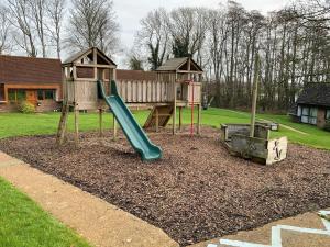 a playground with a slide in a yard at Daisy Cottage in Polegate