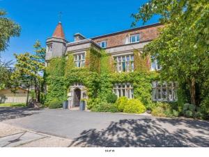 a large brick building with ivy growing on it at Daisy Cottage in Polegate