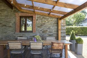 a patio with a wooden table and chairs under a pergola at La Ressource in Cherain