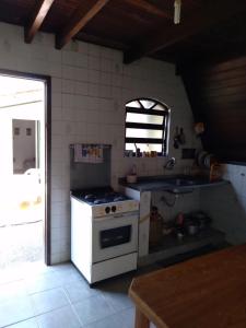 a kitchen with a white stove and a sink at Chalet da vila in Angra dos Reis