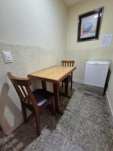 a wooden table and a chair in a room at Hotel Casa Blanca - Adults Only in Rio de Janeiro