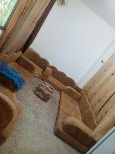 a brown couch sitting in the corner of a room at Flowers in Jerash