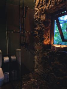 a bathroom with a stone wall and a window at EntreViñas in Carmelo