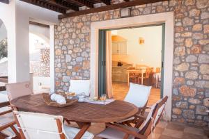 a dining room with a wooden table and chairs at Sky & Sea View Retreat in Telendos