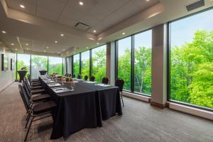 a conference room with tables and chairs and large windows at Hôtel-Musée Premières Nations in Wendake +60 photos