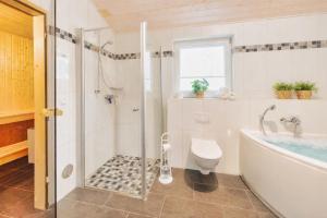 a bathroom with a shower and a tub and a toilet at Haus Stressfrei - Nordhorn in Nordhorn +24 photos