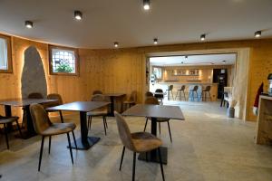 a restaurant with wooden walls and tables and chairs at Grey Castle garnì&suite in Ponte di Legno