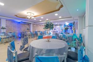 a banquet hall with a table and blue chairs at Hotel Presidente Internacional in Guayaquil