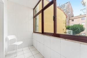 a room with a window and a white chair at GuestReady - Gaia Gardens Apartments in Vila Nova de Gaia