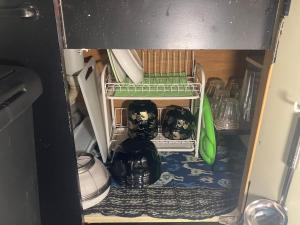 a cupboard with some dishes on a shelf in a kitchen at 民泊寿屋Kotobukiya Guesthouse in Muroran