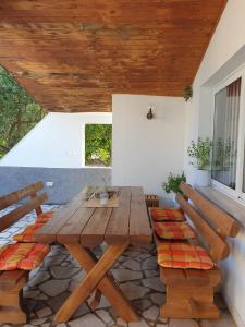 a wooden table and benches on a patio at Orebic BnB in Orebić