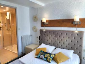 a bedroom with a bed and a glass shower at Logis HOTEL RESTAURANT La Régence in Cherbourg en Cotentin