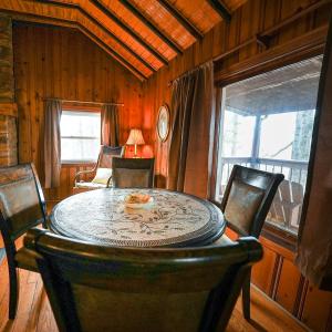 a dining room with a table and chairs and a room with a window at Settler - by The Chalets in Logan