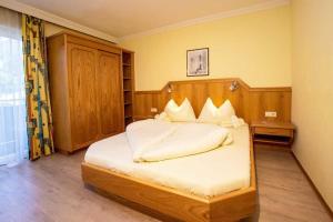 a bedroom with a large bed with a wooden headboard at B&B Kaiserstube in Flachau