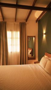 a bedroom with a bed with a window and a mirror at Hotel Jardin Boutique rodadero in Santa Marta