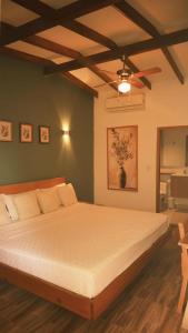 a bedroom with a large bed with a ceiling fan at Hotel Jardin Boutique rodadero in Santa Marta