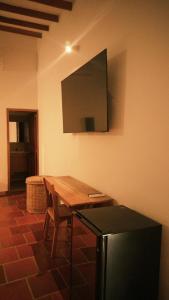a kitchen with a table and a television on the wall at Hotel Jardin Boutique rodadero in Santa Marta