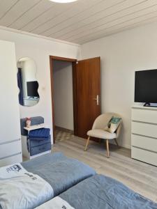 a bedroom with a bed and a tv and a chair at Orebic BnB in Orebić