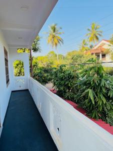 a balcony of a house with a blue floor and palm trees at Lumora - Midigama in Midigama East