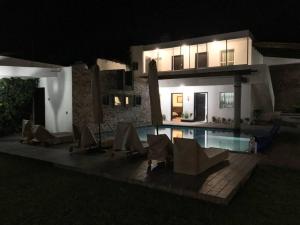 a house with a swimming pool at night at La casa flores in Atlixco