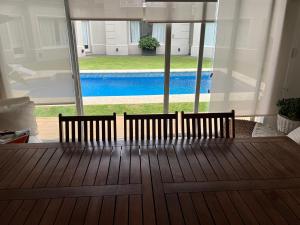 a wooden bench sitting on a porch with a view of a pool at Blue House in San Pedro