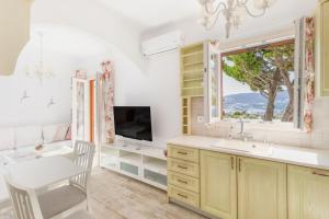 a kitchen with a sink and a window at ĪKADE Mykonos in Mikonos