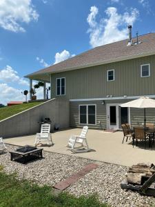 a patio with chairs and an umbrella and a house at Bourbon Trail Pool & Hot-Tub FUN-ZONE! Game Room! Pool Table! Golden Tee! Ping Pong! Luxurious and Spacious Master Bedroom! Fishing Offsite! in Springfield