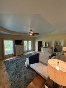 a living room with a bed and a ceiling fan at Bourbon Trail Pool & Hot-Tub FUN-ZONE! Game Room! Pool Table! Golden Tee! Ping Pong! Luxurious and Spacious Master Bedroom! Fishing Offsite! in Springfield