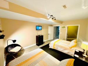 a bedroom with two beds and a tv on the wall at Bourbon Trail Pool & Hot-Tub FUN-ZONE! Game Room! Pool Table! Golden Tee! Ping Pong! Luxurious and Spacious Master Bedroom! Fishing Offsite! in Springfield +53 photos