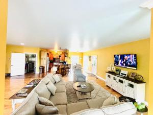 a living room with a couch and a tv at Bourbon Trail Pool & Hot-Tub FUN-ZONE! Game Room! Pool Table! Golden Tee! Ping Pong! Luxurious and Spacious Master Bedroom! Fishing Offsite! in Springfield