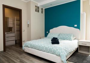 a bedroom with a blue accent wall and a bed at B&B Mary in Alba