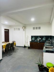 a room with a table and chairs and a kitchen at Lumora - Midigama in Midigama East