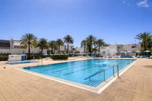 a large swimming pool with palm trees and buildings at Oasis Costa del Silencio - Large Pool & Relax in Costa Del Silencio