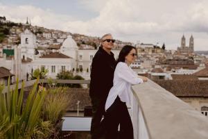 a man and a woman standing on a roof at Casa Santa Clara - Colonial Boutique Hotel in Quito