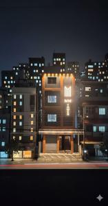 a tall building with a sign on it at night at Nestdormitory in Cochin
