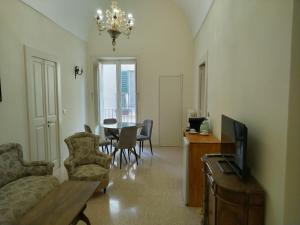 a living room with a couch and a tv and a table at Suite Verdi suite room in Lecce