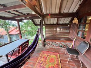 a hammock in a room with a table and a chair at Chaloklum Belvedere B6 in Ko Phangan +13 photos